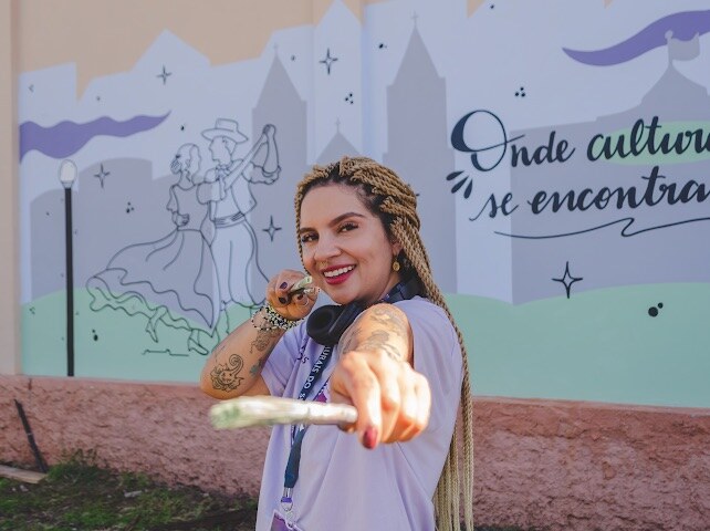 Mari Vilhosa em frente ao mural Onde culturas se encontram