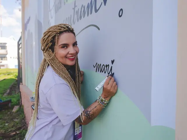 Mari Vilhosa assinando uma de suas obras